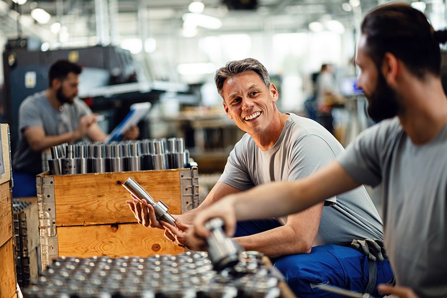 Specialized Business Insurance - Smiling Employees Working In Manufacturing Facility